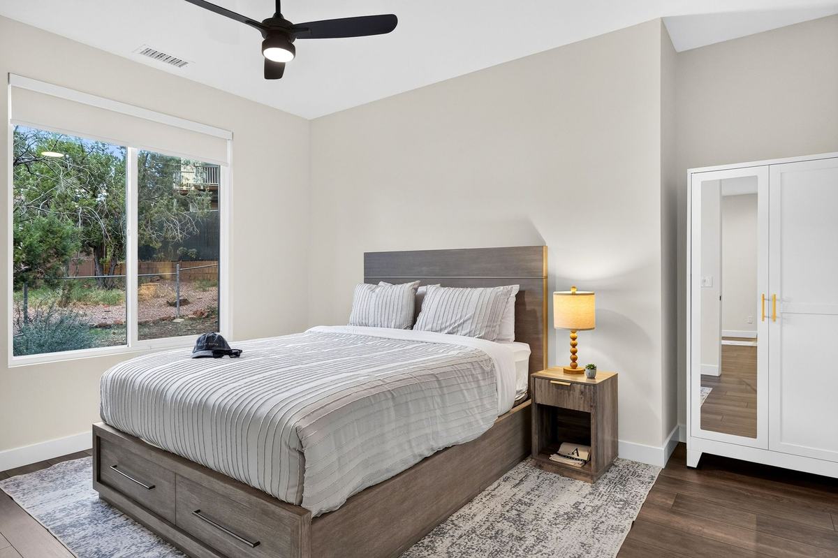 A guest bedroom with a window onto the trees.