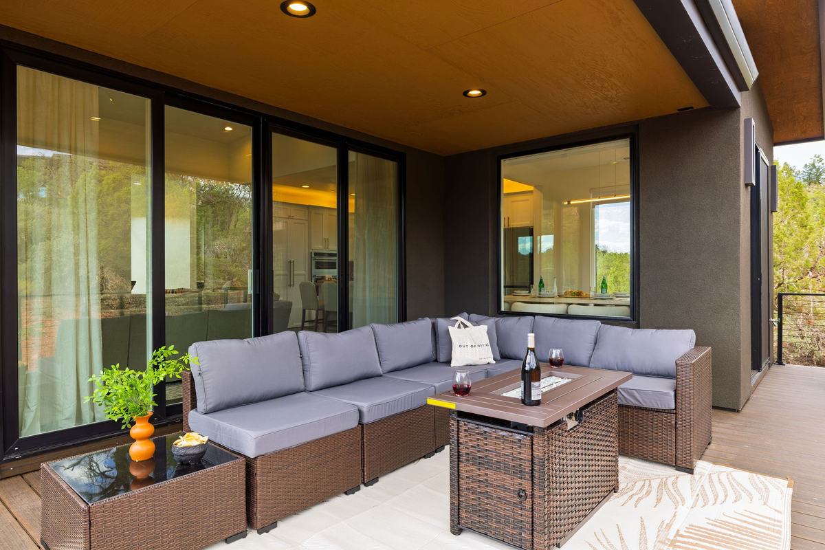 Covered lounge with a sectional and fire table.